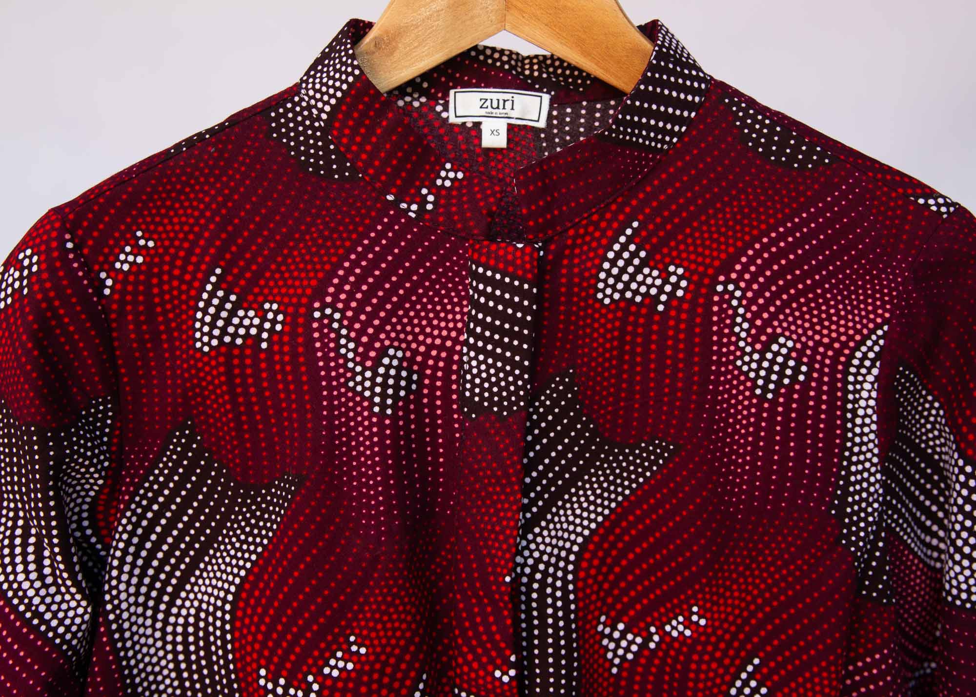 Display of merlot red, brown, red , coral and white abstract line print dress