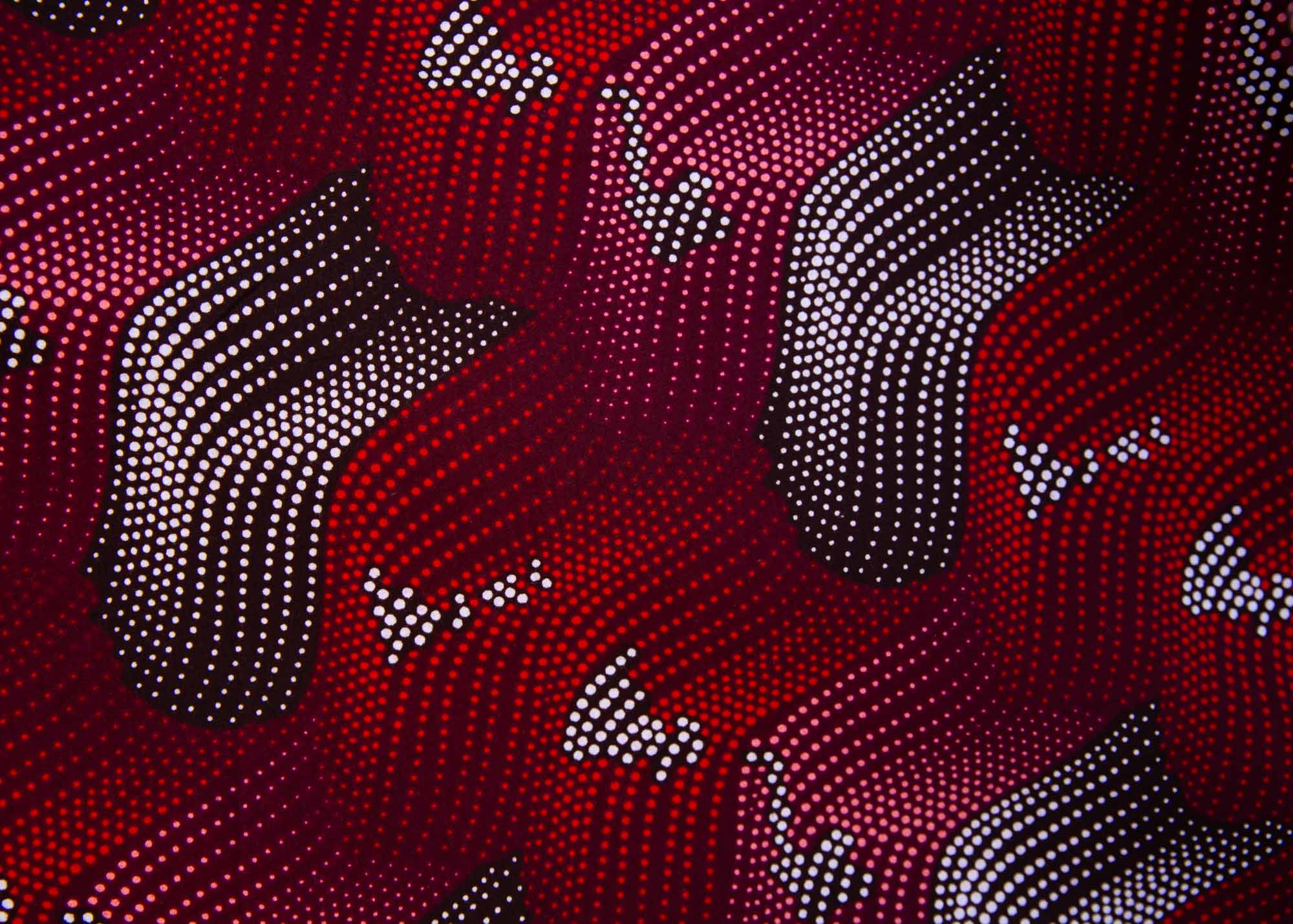 Close up display of merlot red, brown, red , coral and white abstract line print dress