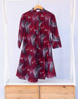 Display of merlot red, brown, red , coral and white abstract line print dress