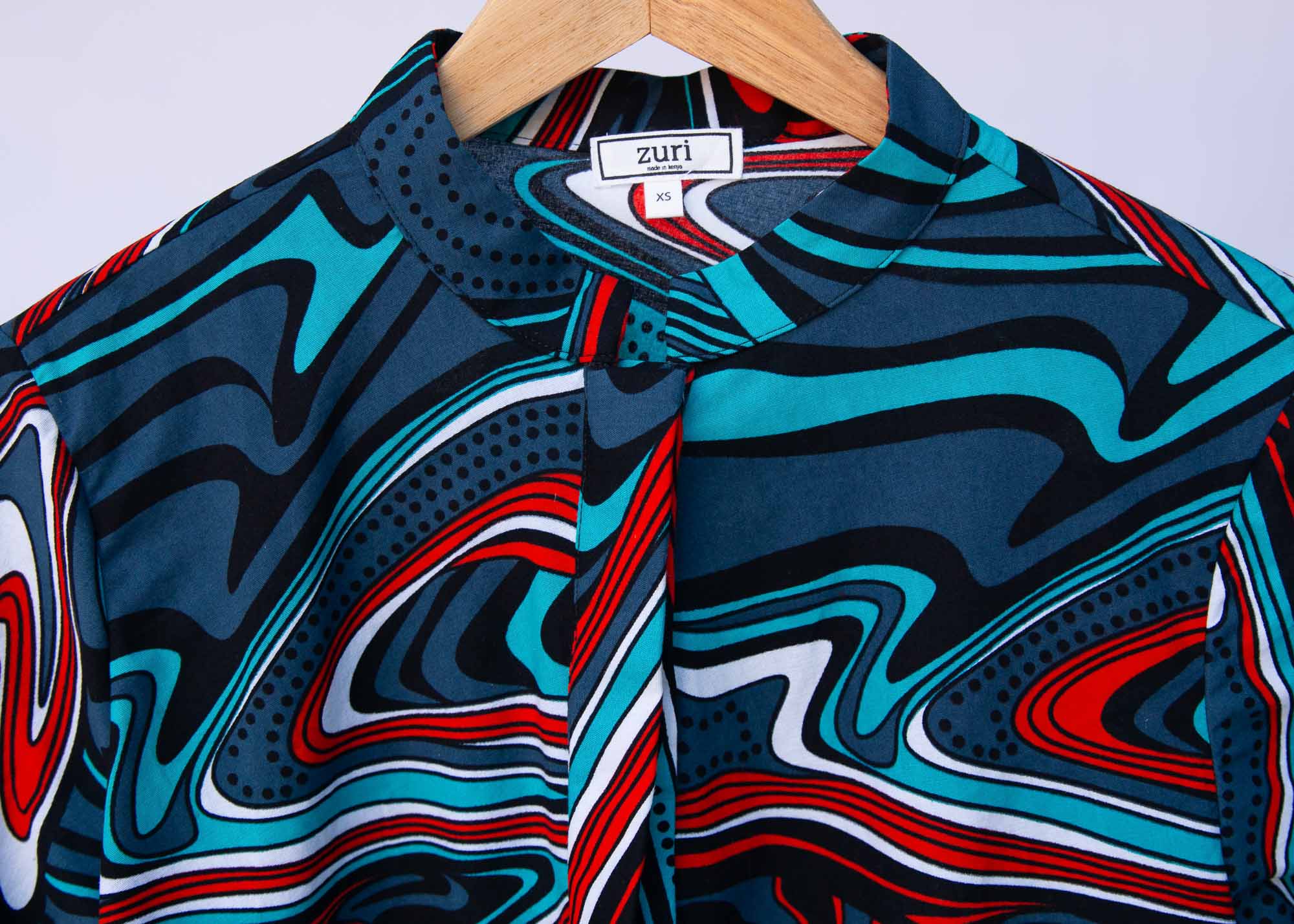 Display of turquoise, black, slate, white and red abstract print dress