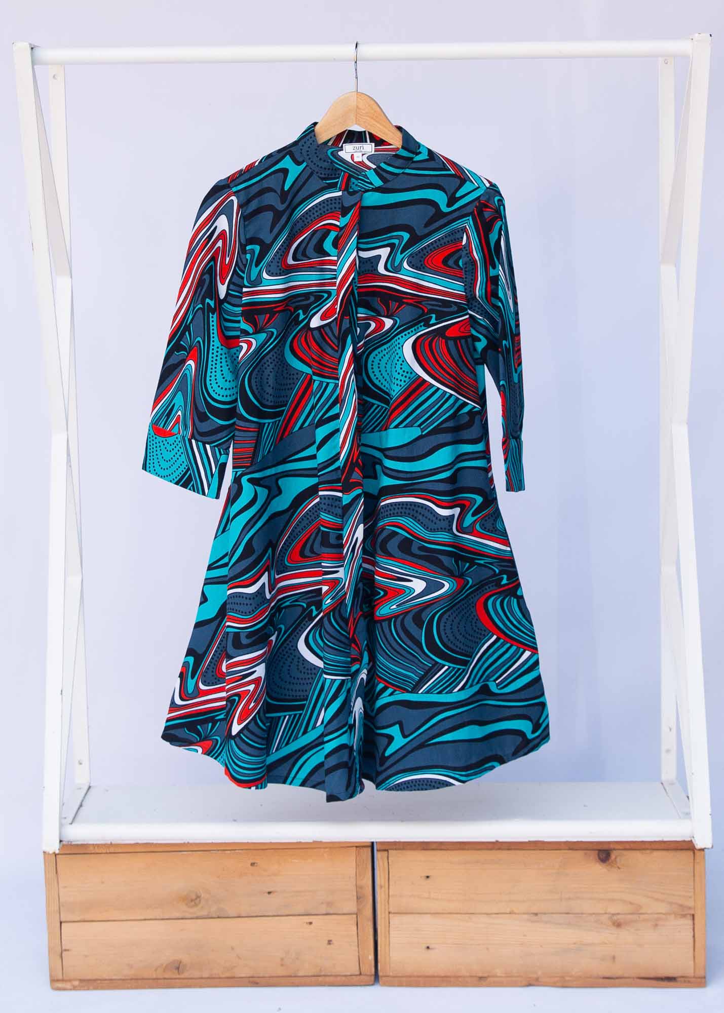 Display of turquoise, black, slate, white and red abstract print dress