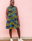 The model is wearing black dress with purple , yellow and turquoise dotted fans