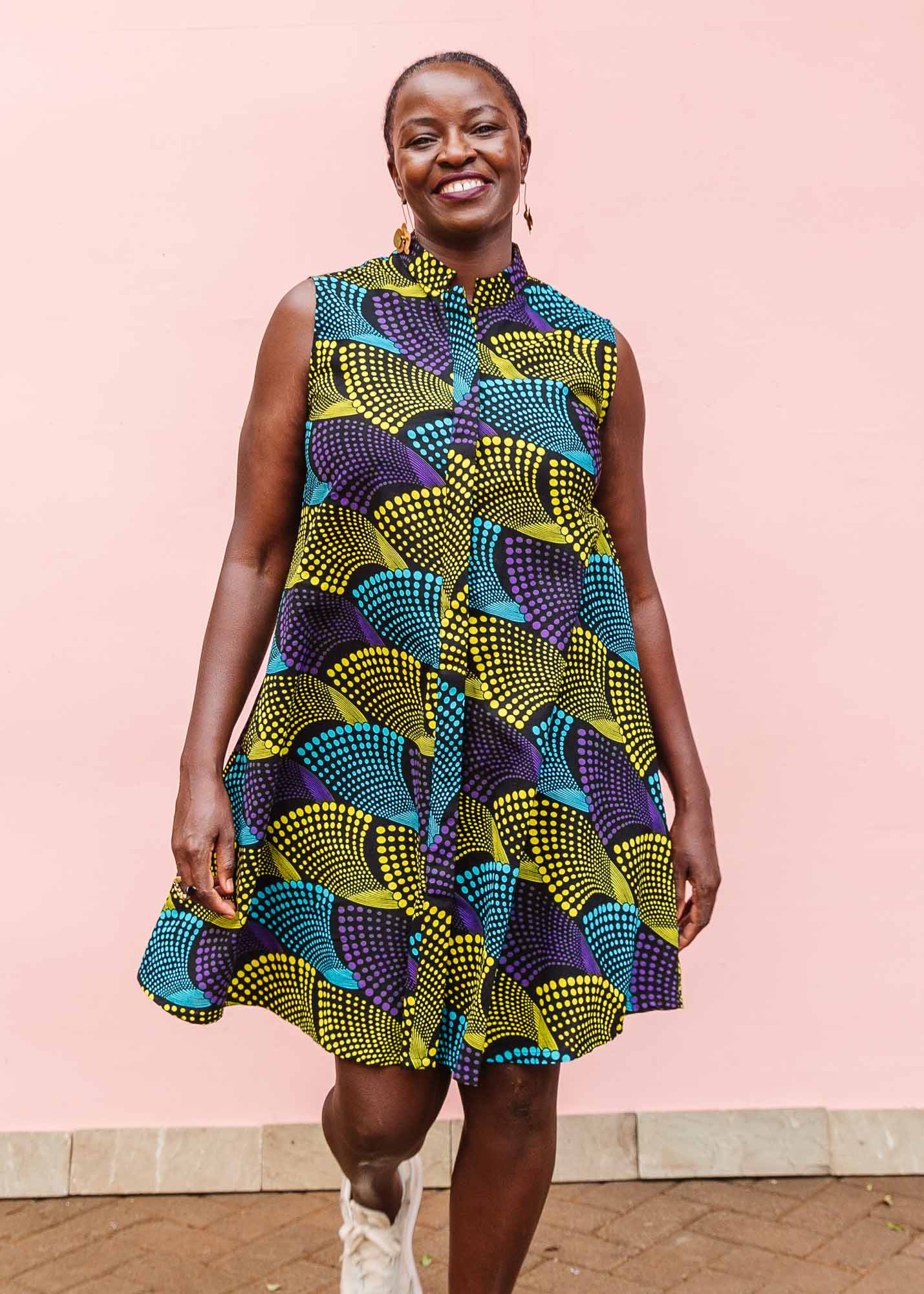 The model is wearing black dress with purple , yellow and turquoise dotted fans