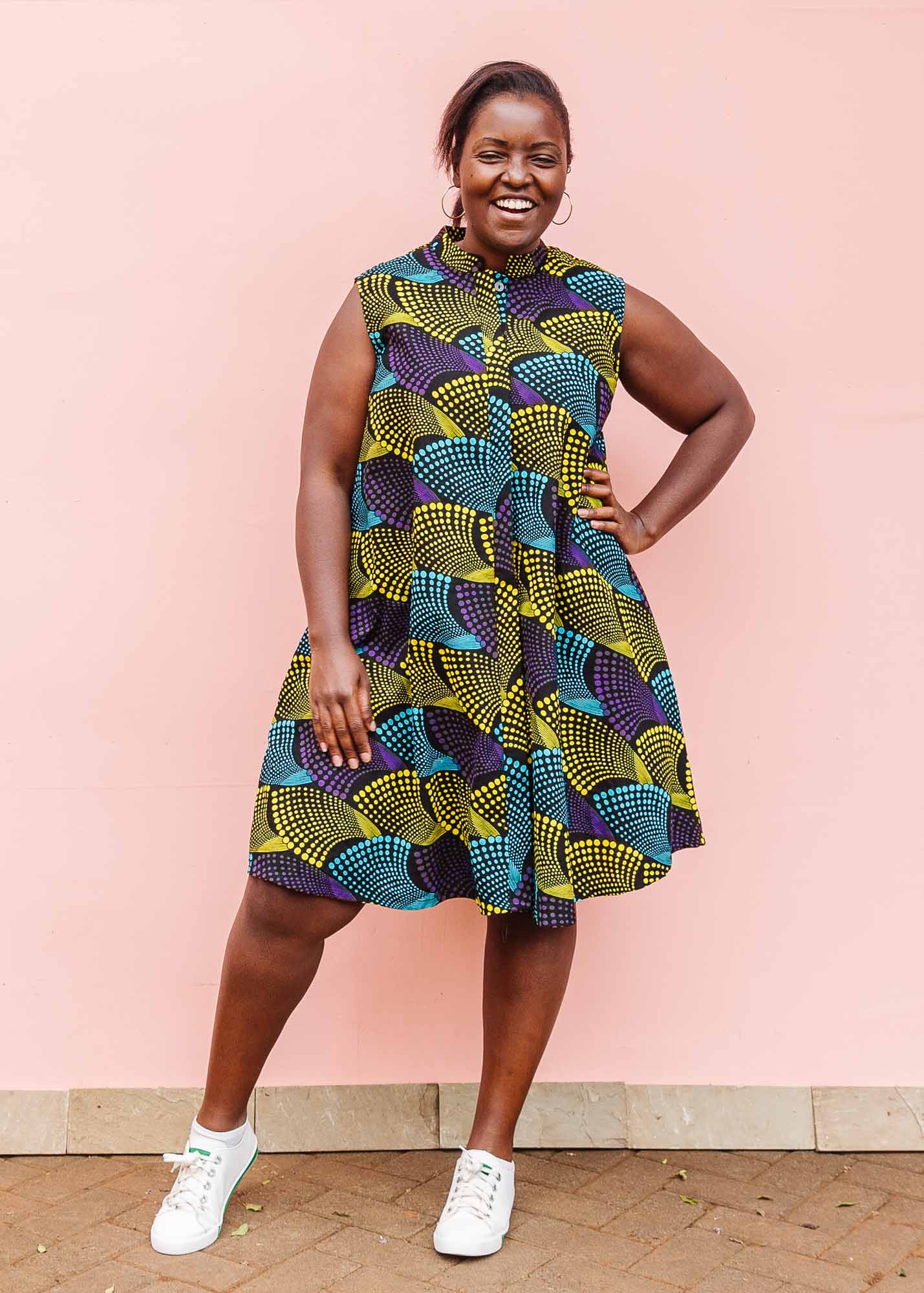 The model is wearing black dress with purple , yellow and turquoise dotted fans