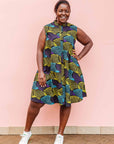 The model is wearing black dress with purple , yellow and turquoise dotted fans