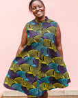 The model is wearing black dress with purple , yellow and turquoise dotted fans