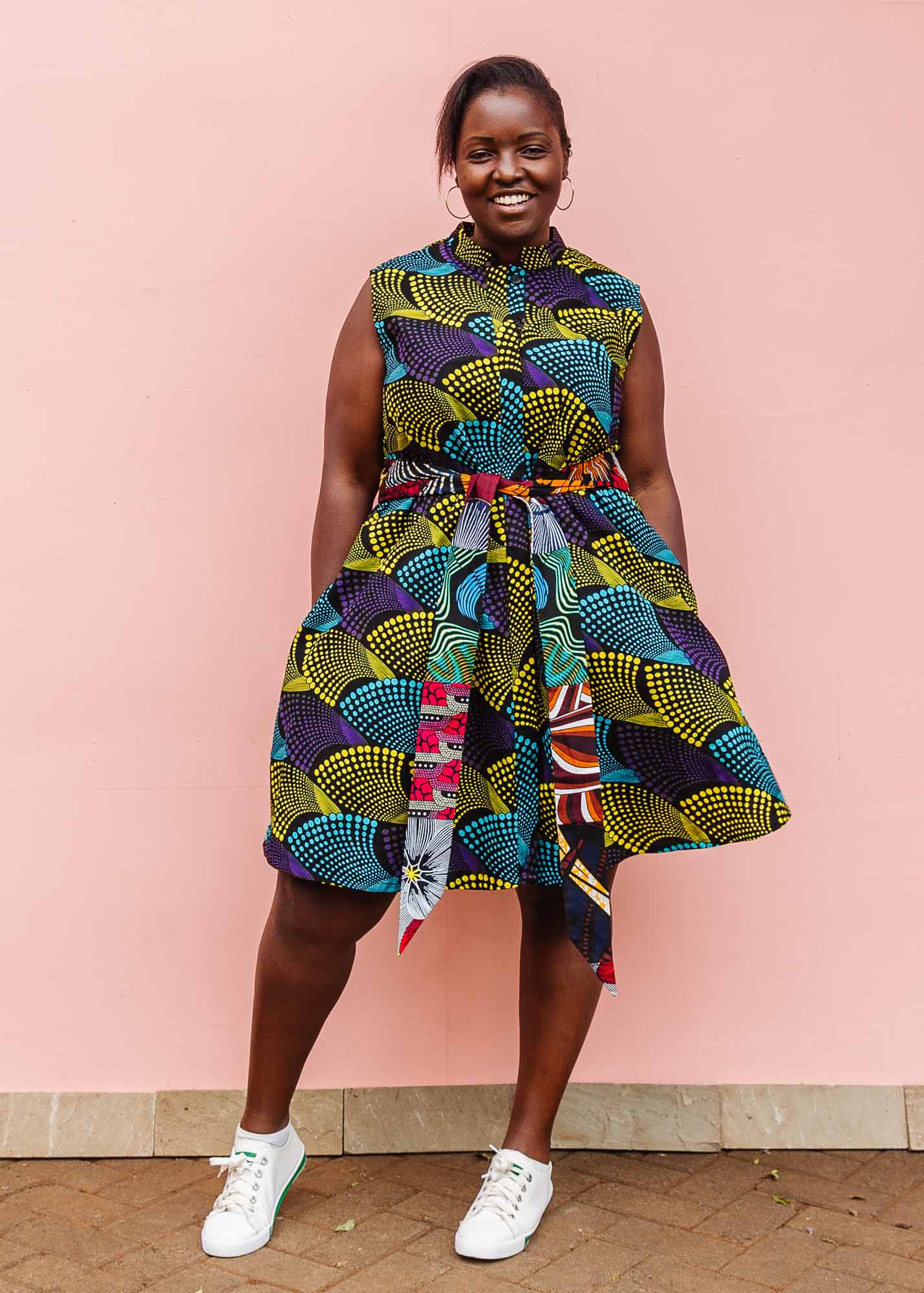 The model is wearing black dress with purple , yellow and turquoise dotted fans