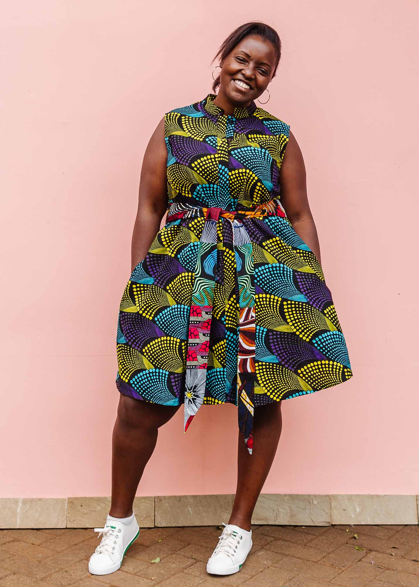 The model is wearing black dress with purple , yellow and turquoise dotted fans