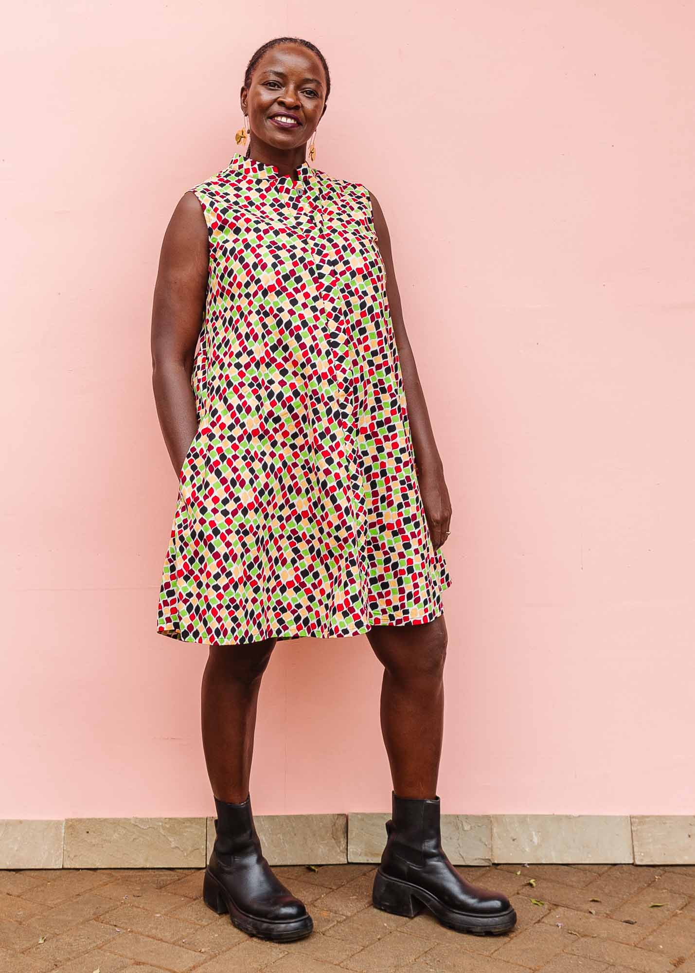 The model is wearing multi-colored scallop tiles print dress