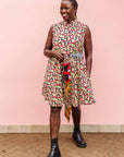 The model is wearing multi-colored scallop tiles print dress