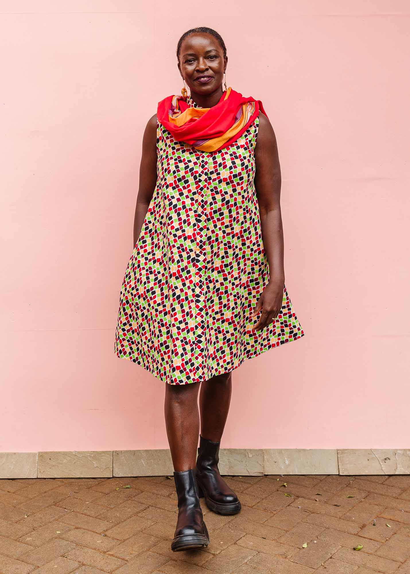 The model is wearing multi-colored scallop tiles print dress