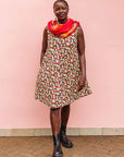 The model is wearing multi-colored scallop tiles print dress