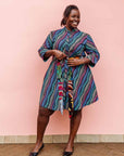 The model is wearing pink, blue, turquoise and beige abstract line dress.
