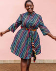 The model is wearing pink, blue, turquoise and beige abstract line dress.