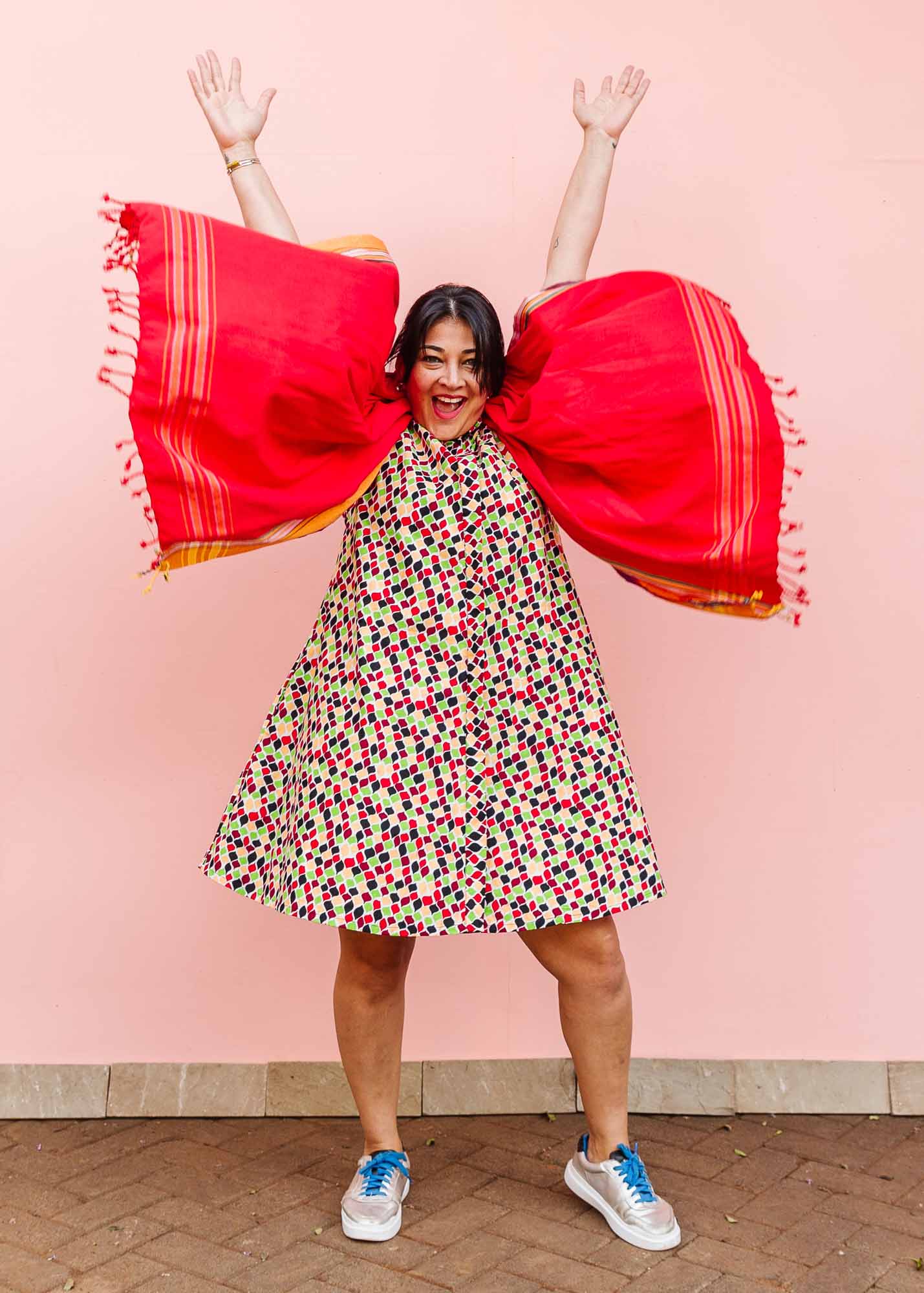 The model is wearing multi-colored scallop tiles print dress