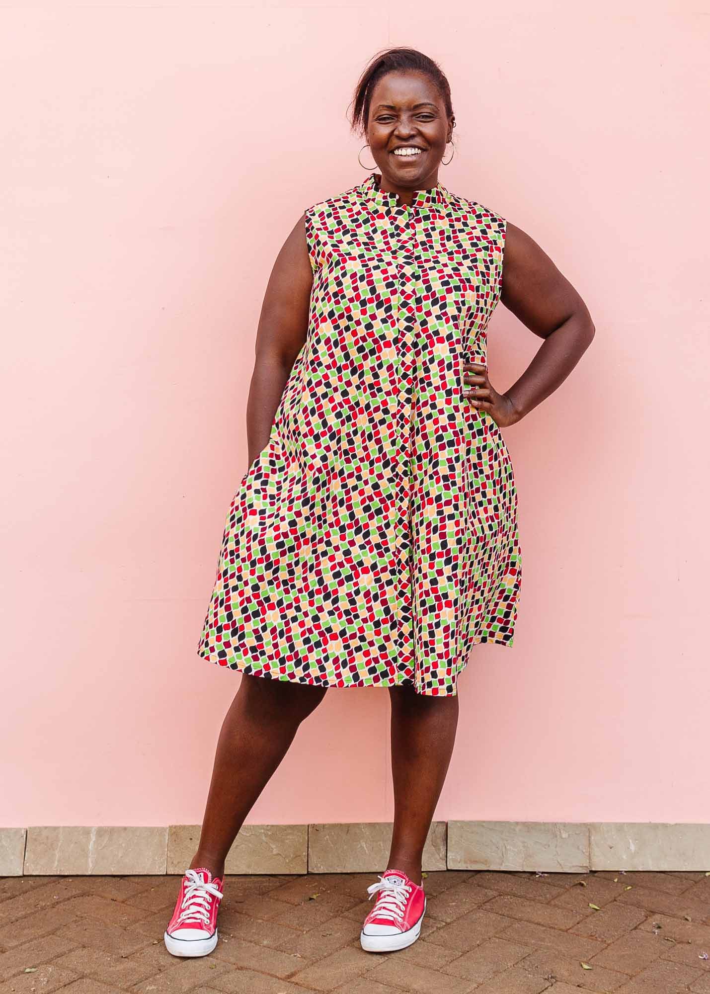 The model is wearing multi-colored scallop tiles print dress