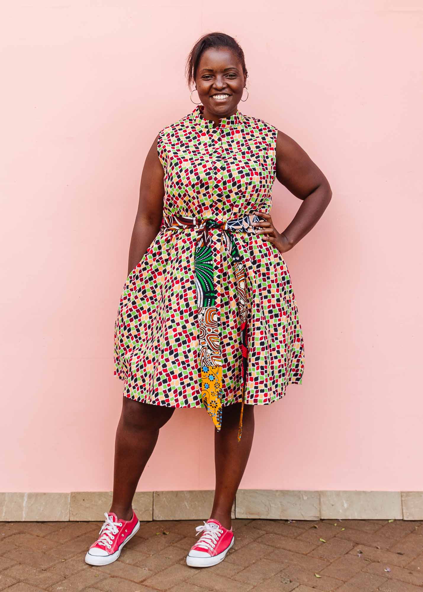 The model is wearing multi-colored scallop tiles print dress