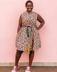 The model is wearing multi-colored scallop tiles print dress