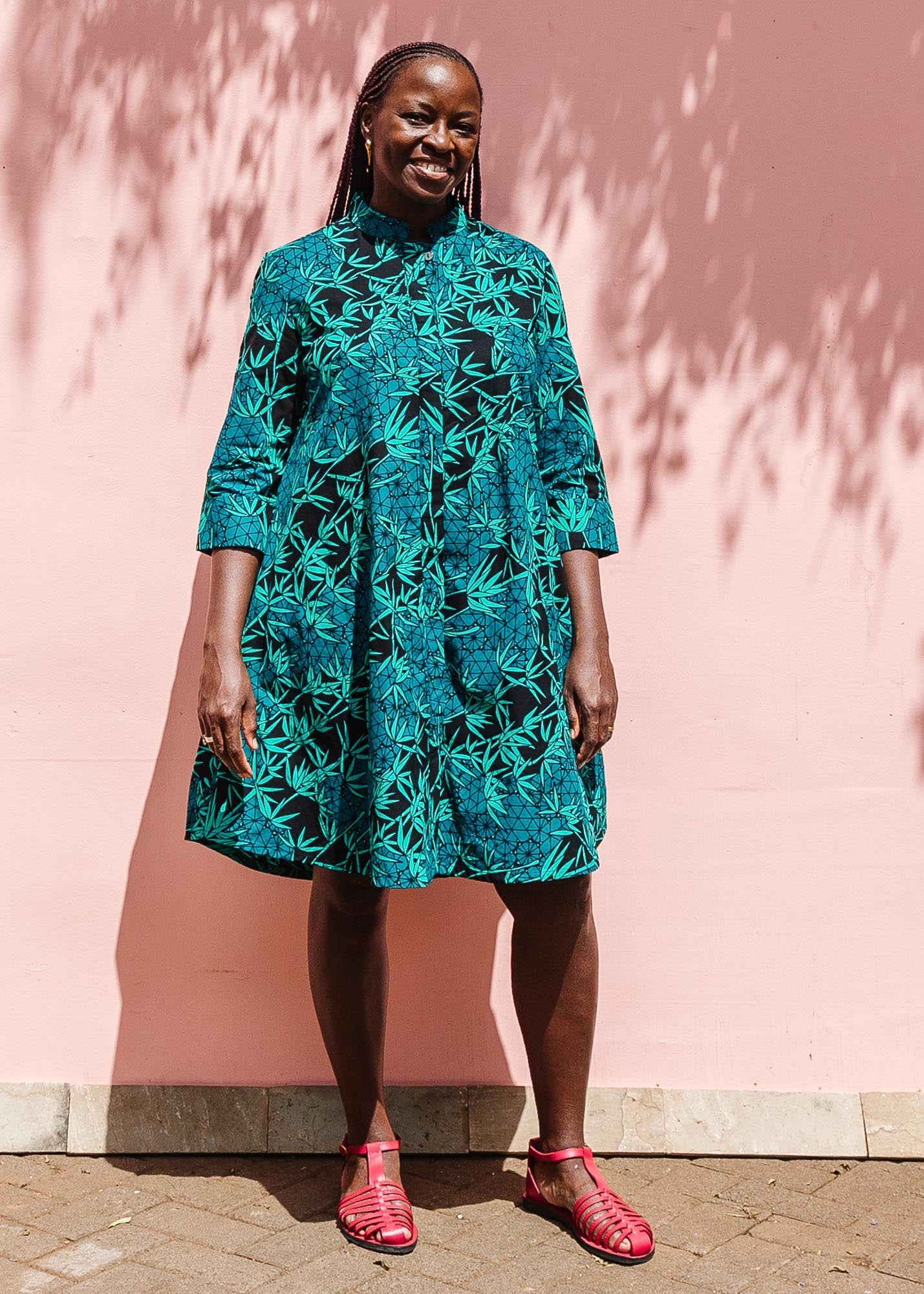 The model is wearing black, blue,  green print dress