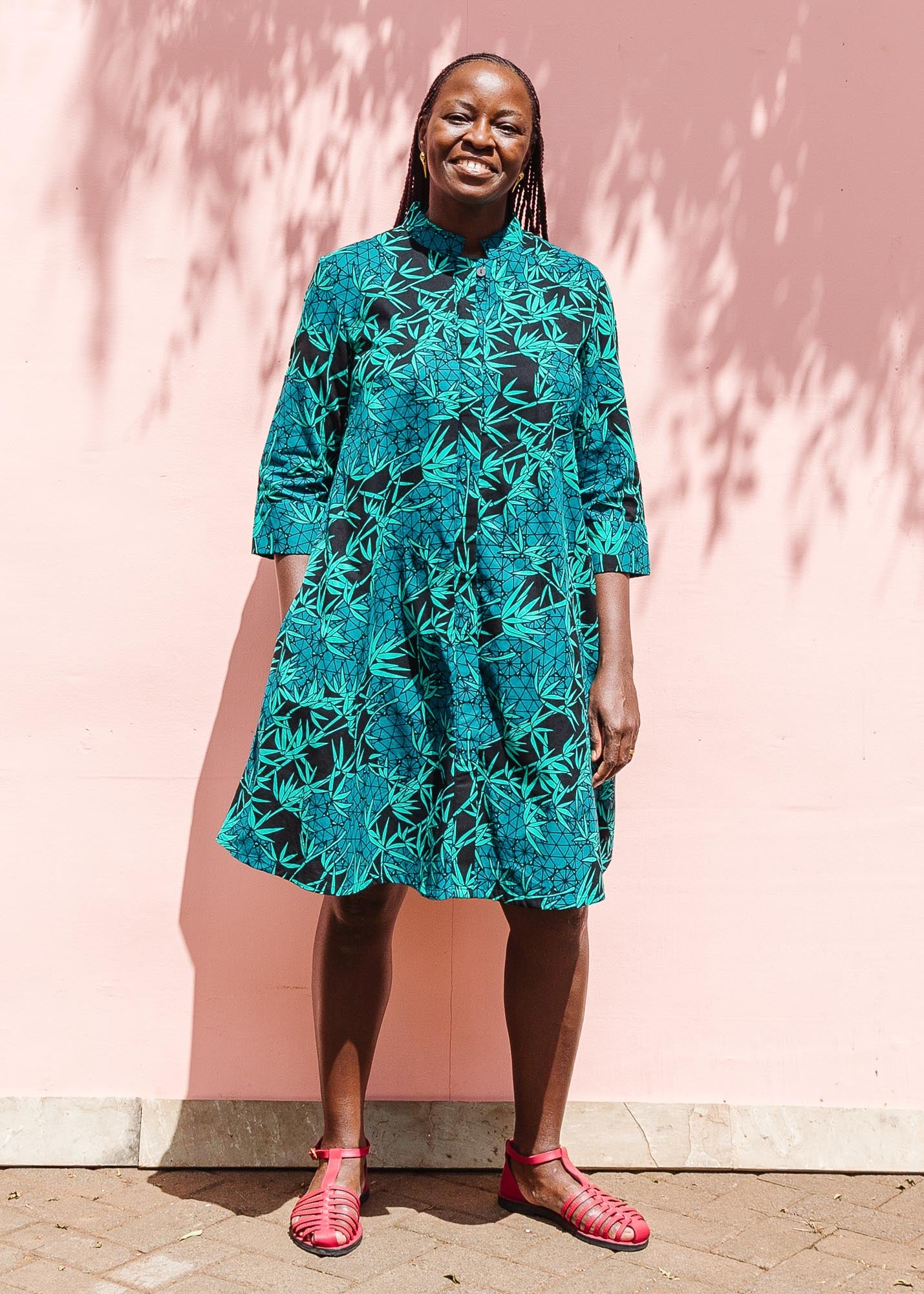 The model is wearing black, blue,  green print dress