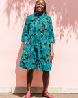 The model is wearing black, blue, green print dress