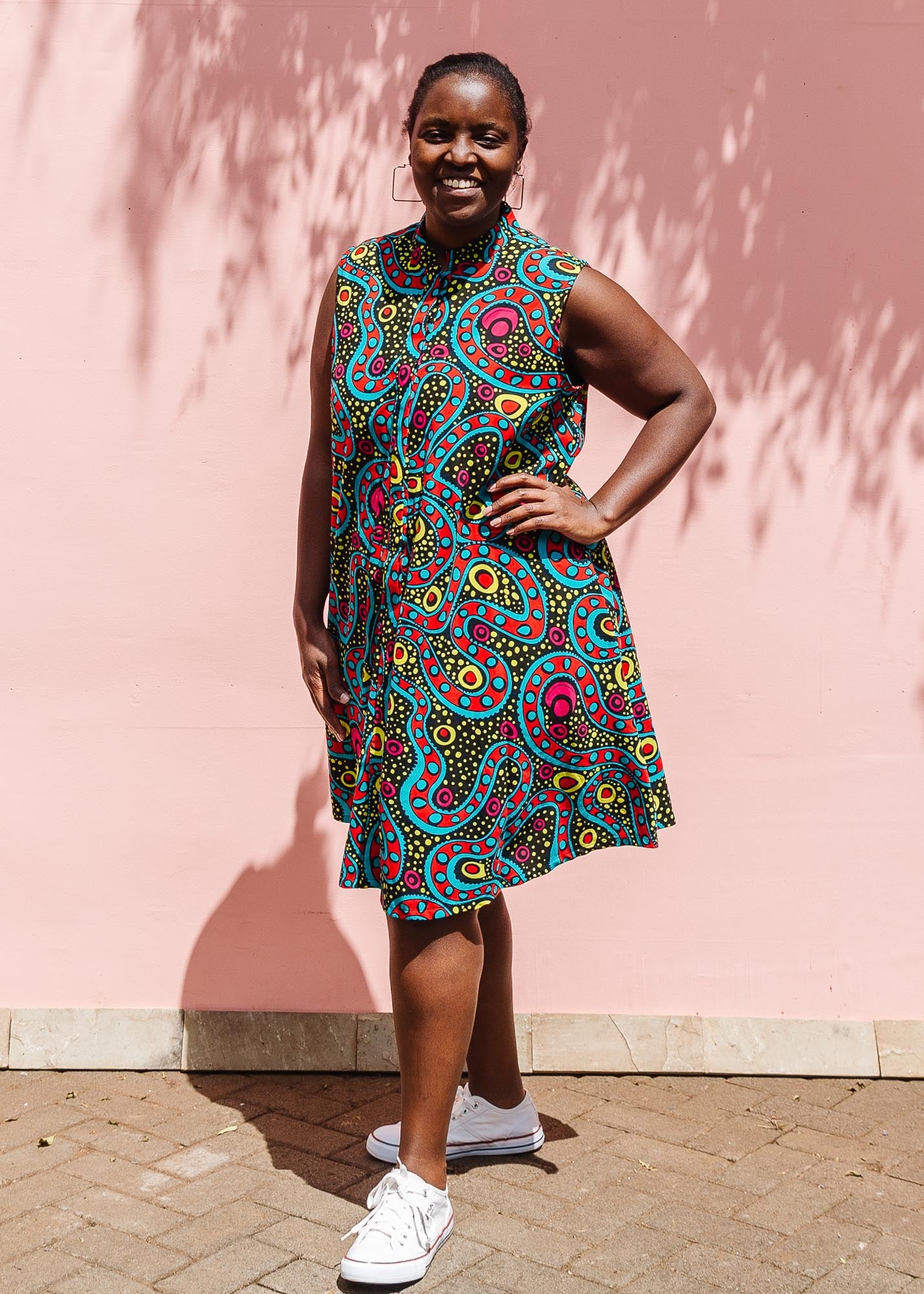 The model is wearing black, yellow, blue, red, pink print dress
