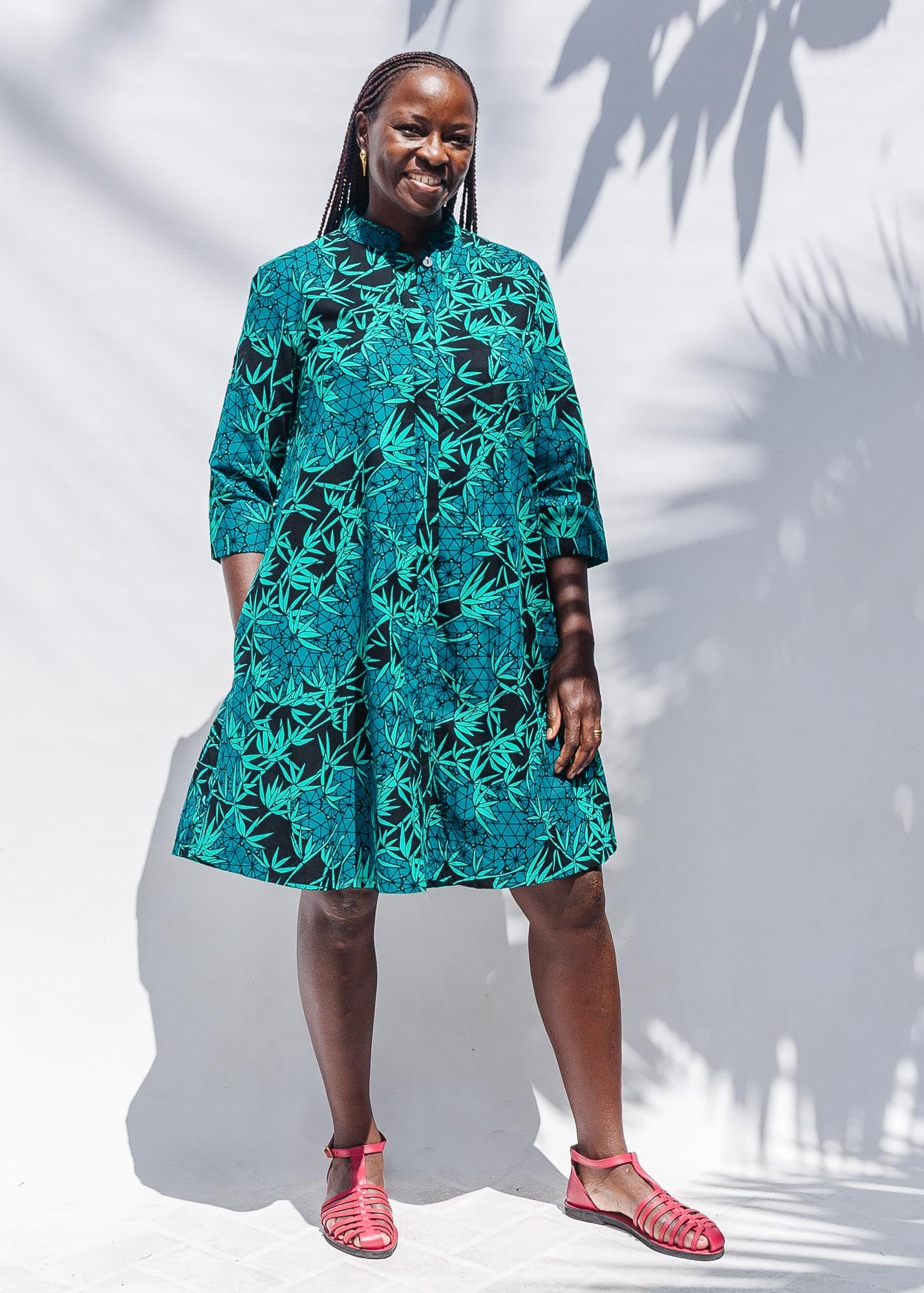 The model is wearing black, blue,  green print dress