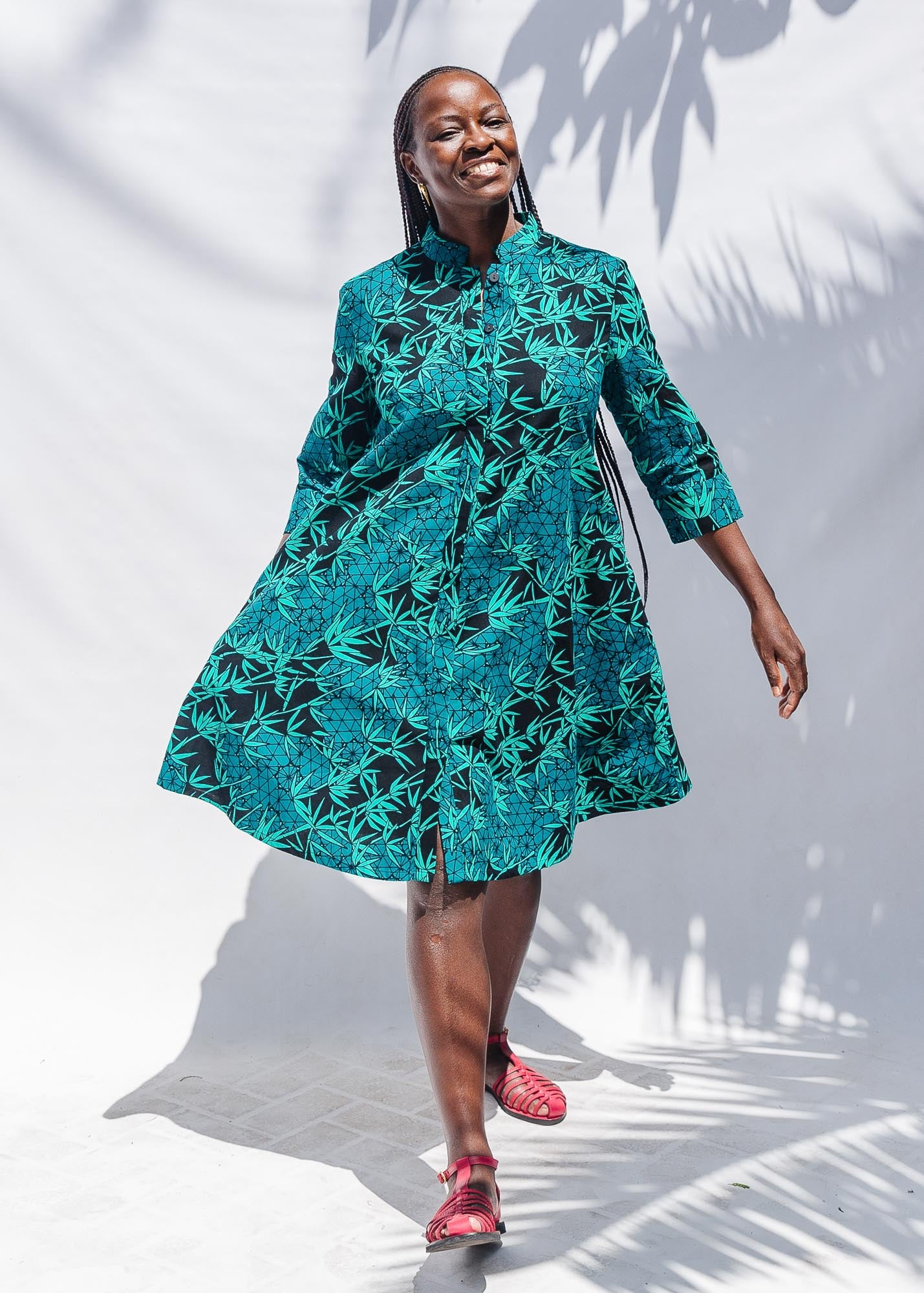 The model is wearing black, blue,  green print dress