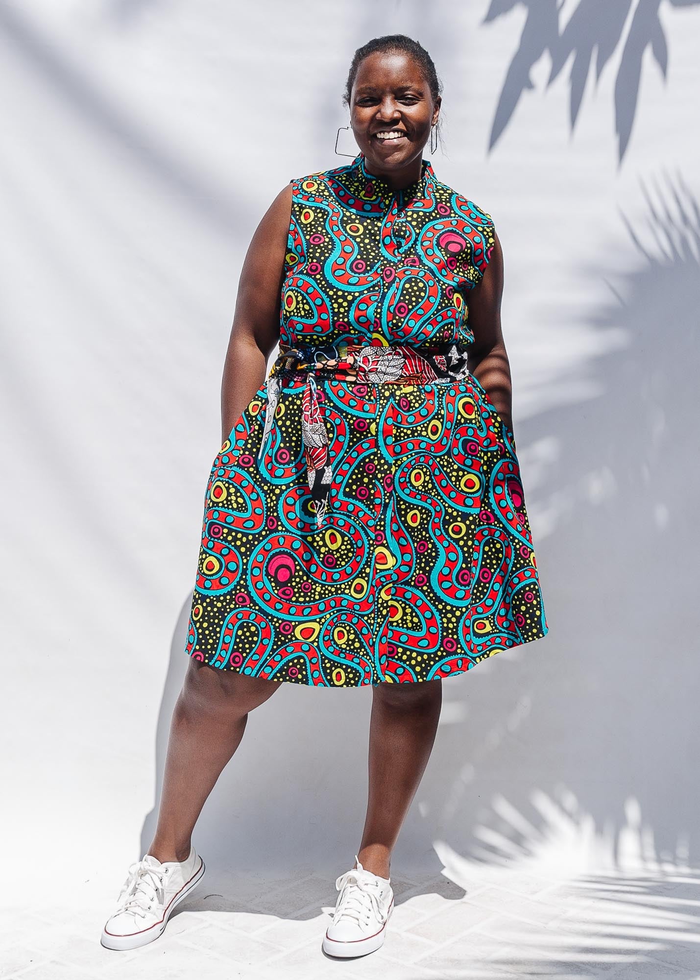 The model is wearing black, yellow, blue, red, pink print dress