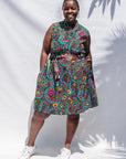 The model is wearing black, yellow, blue, red, pink print dress