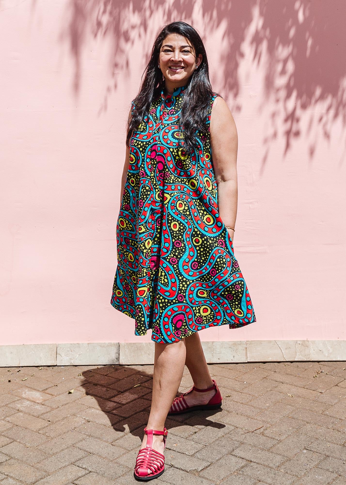 The model is wearing black, yellow, blue, red, pink print dress