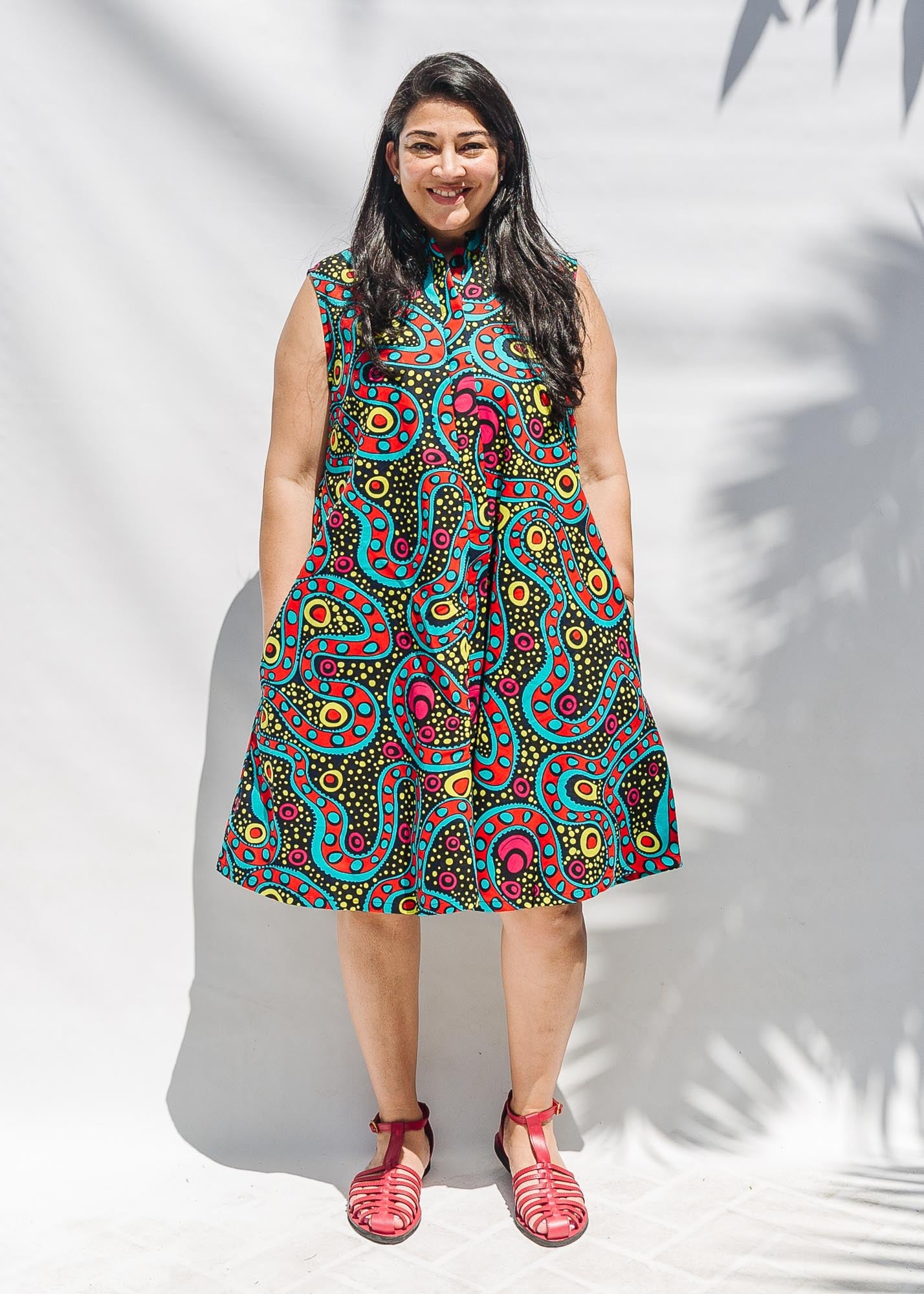 The model is wearing black, yellow, blue, red, pink print dress