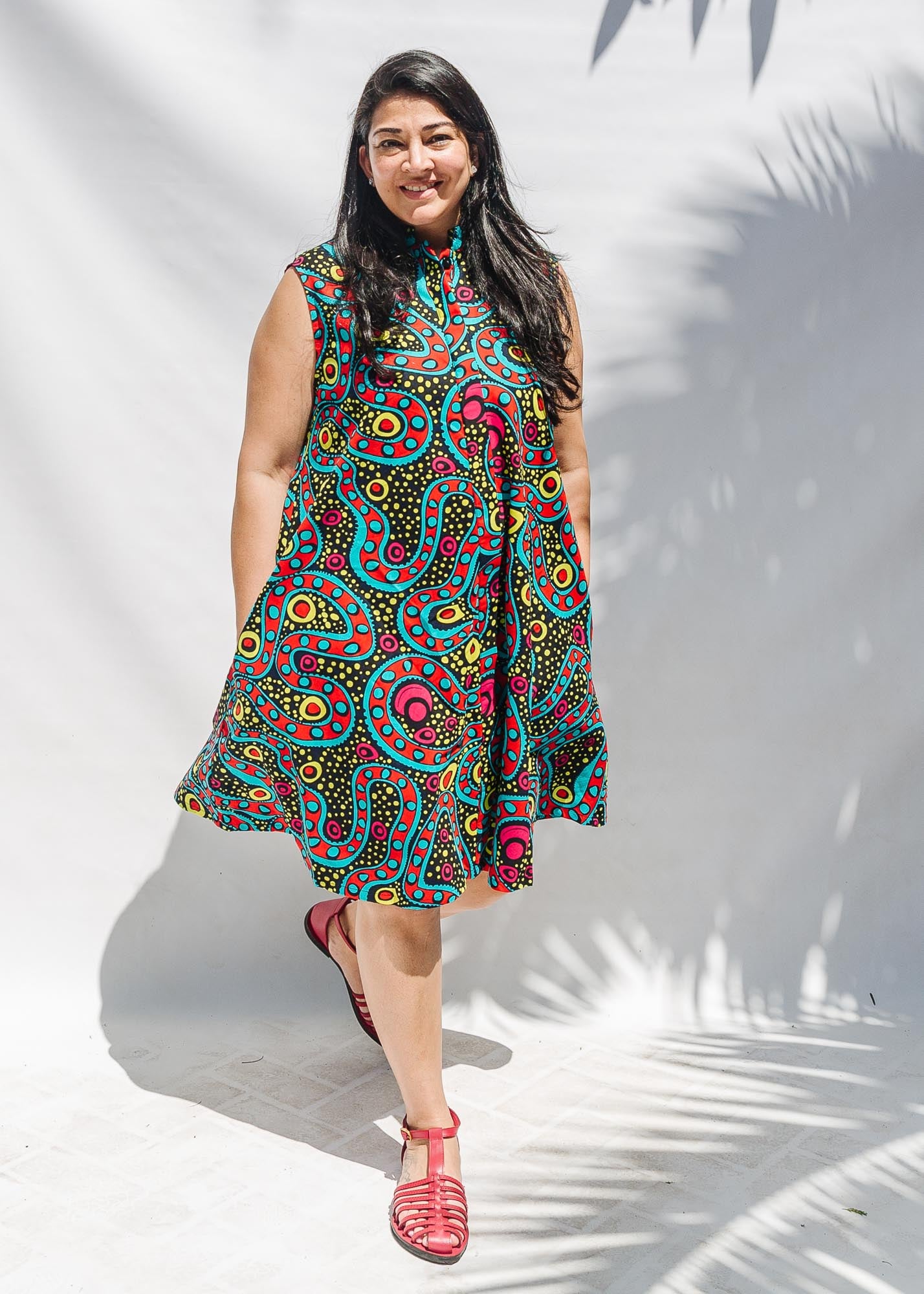 The model is wearing black, yellow, blue, red, pink print dress