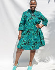 The model is wearing black, blue, green print dress
