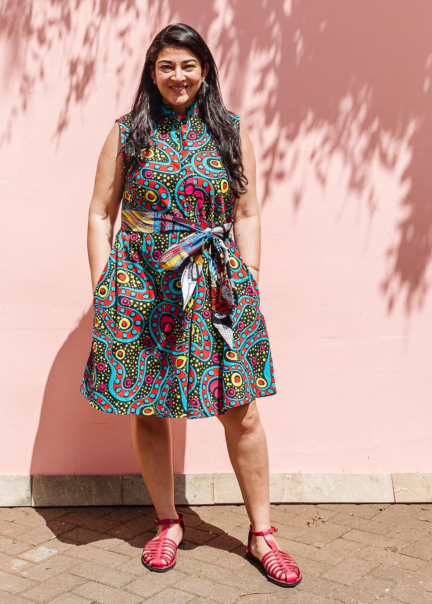 The model is wearing black, yellow, blue, red, pink print dress