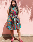 The model is wearing black, yellow, blue, red, pink print dress