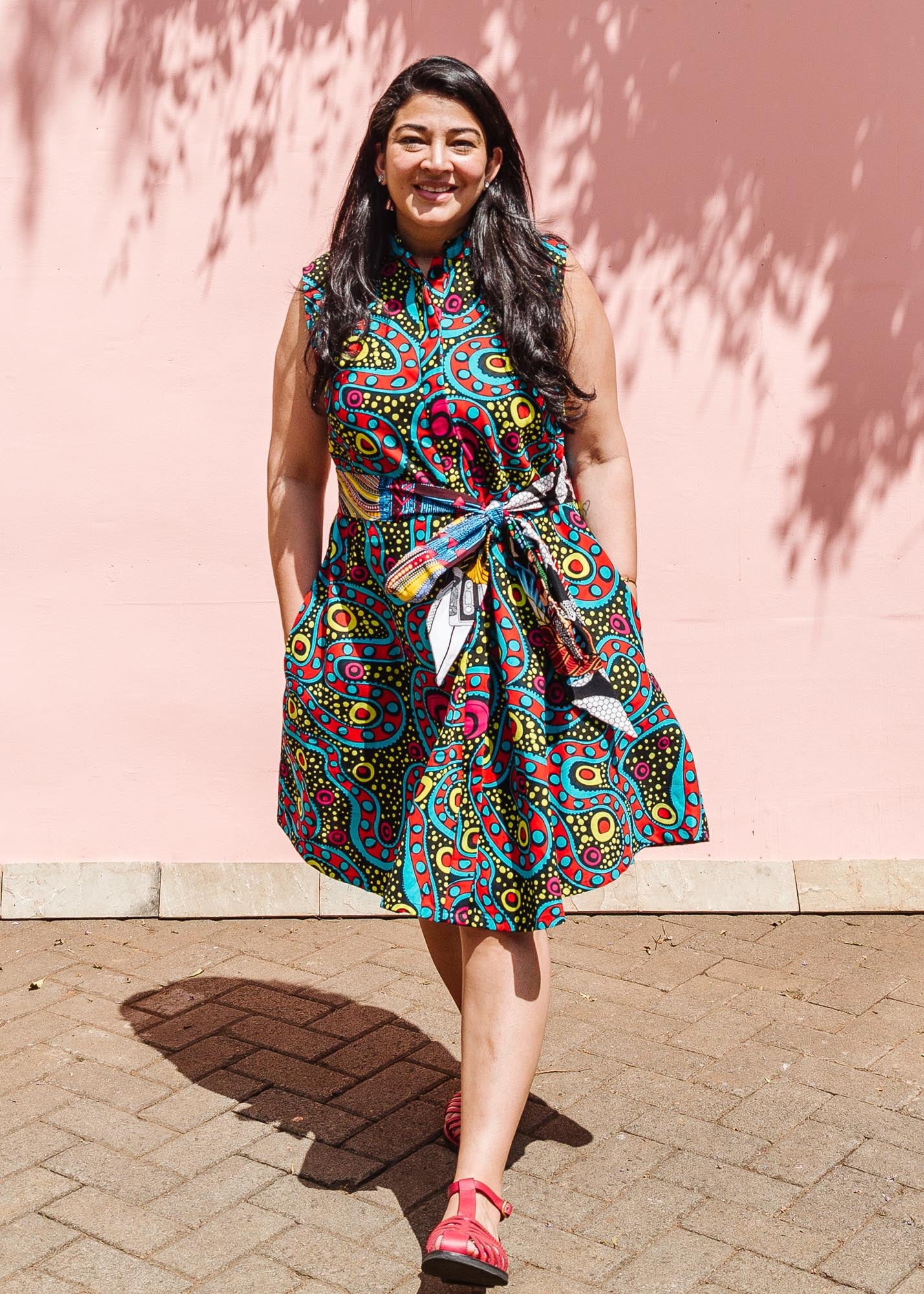 The model is wearing black, yellow, blue, red, pink print dress