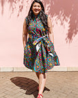 The model is wearing black, yellow, blue, red, pink print dress