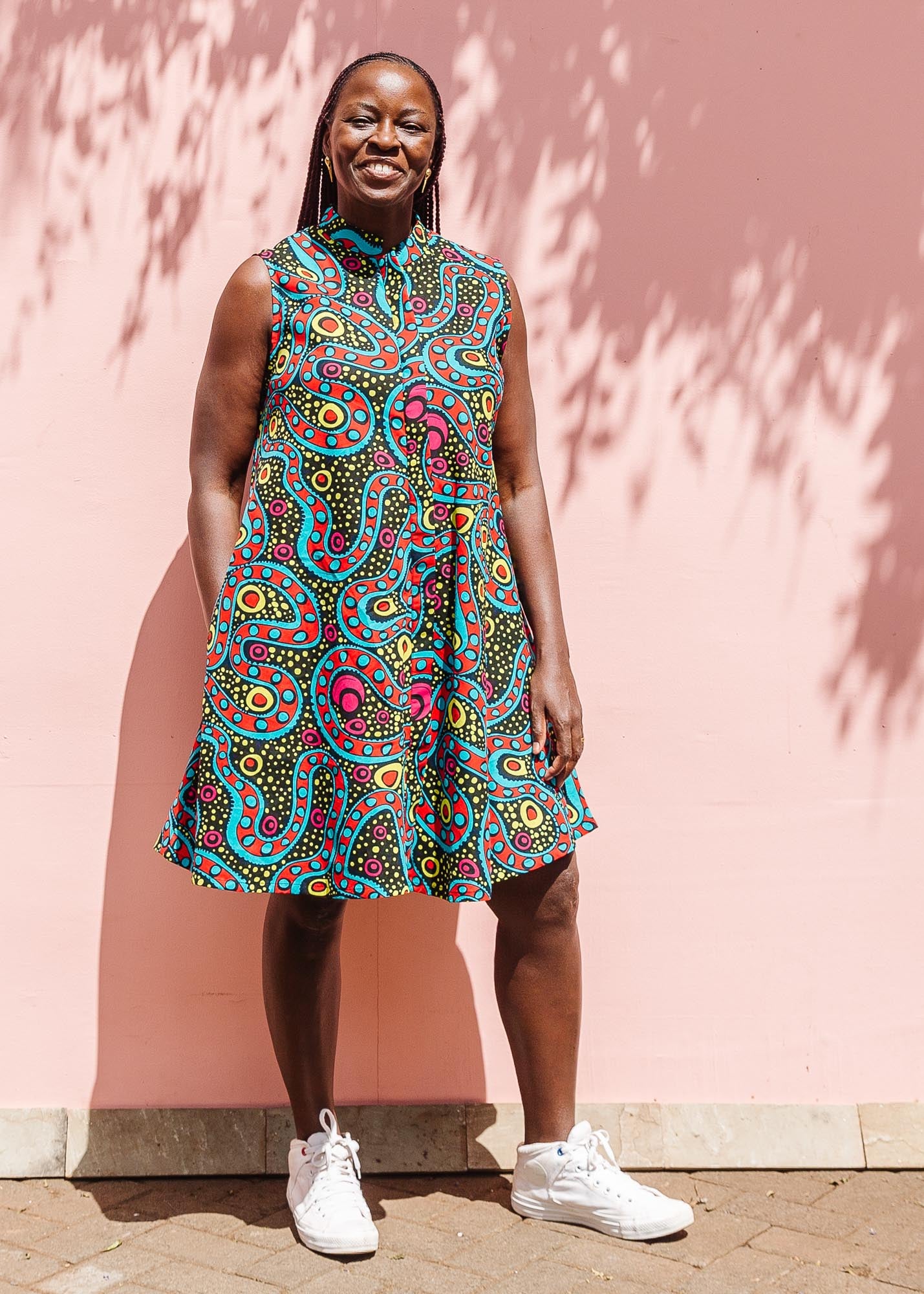 The model is wearing black, yellow, blue, red, pink print dress