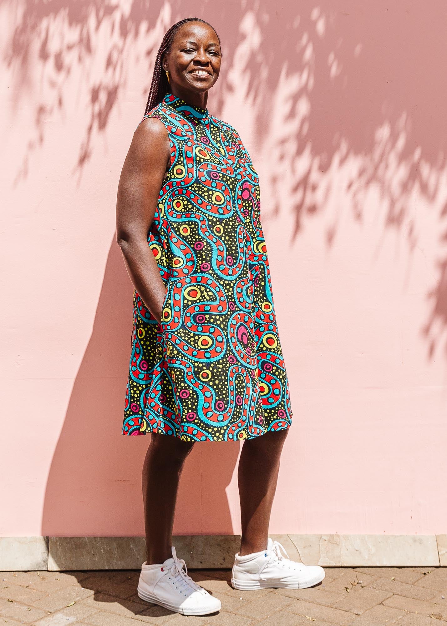 The model is wearing black, yellow, blue, red, pink print dress