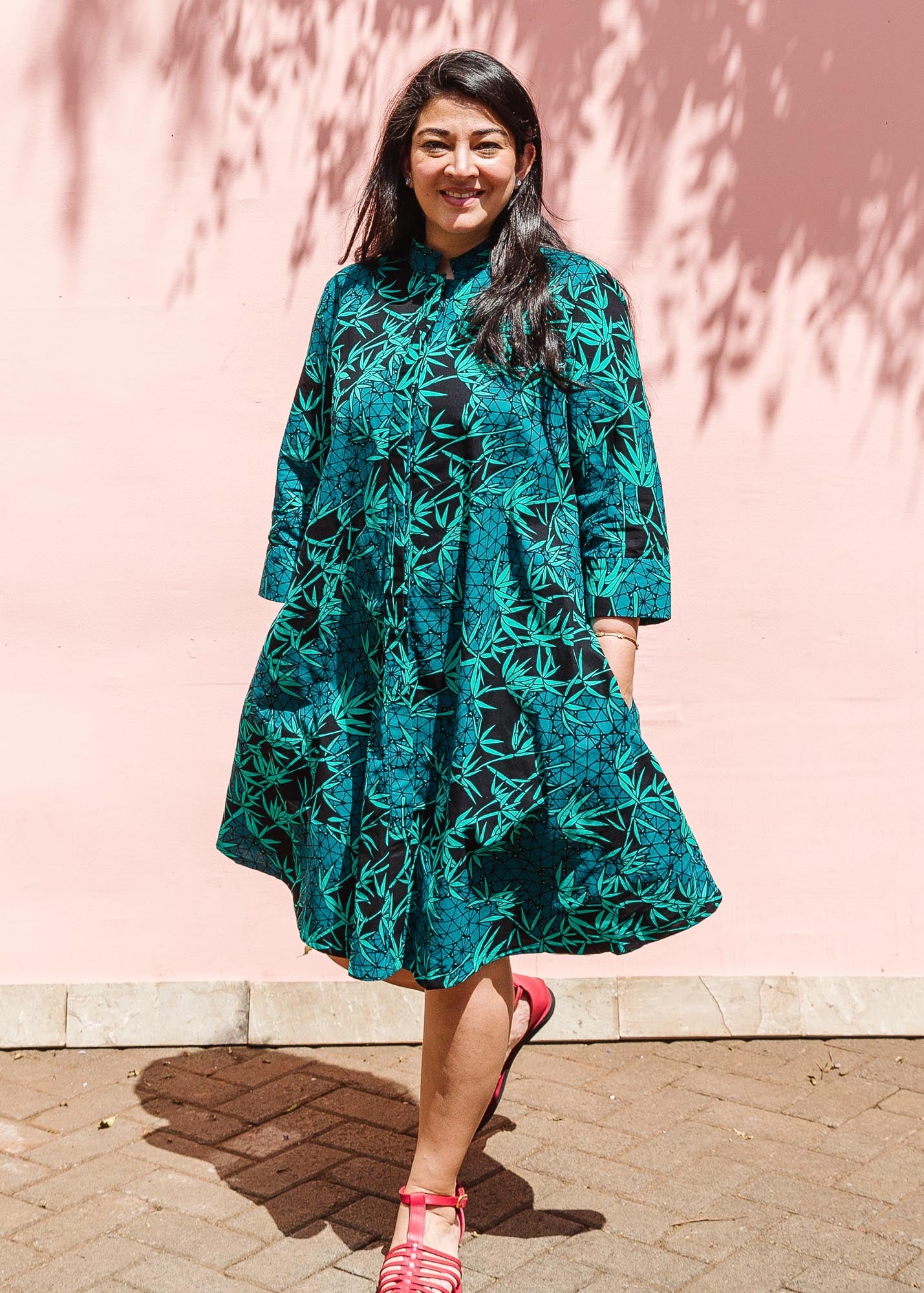 The model is wearing black, blue,  green print dress