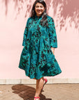 The model is wearing black, blue, green print dress