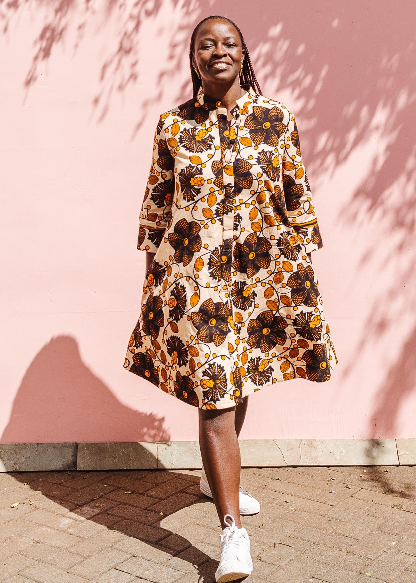 The model is wearing navy, black, off white, yellow flower print dress