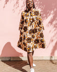 The model is wearing navy, black, off white, yellow flower print dress
