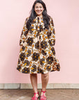 The model is wearing navy, black, off white, yellow flower print dress