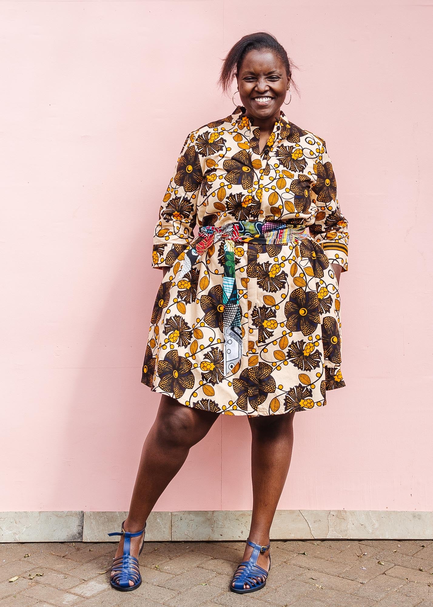 The model is wearing navy, black, off white, yellow flower print dress