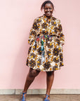 The model is wearing navy, black, off white, yellow flower print dress