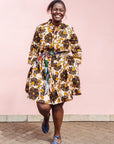 The model is wearing navy, black, off white, yellow flower print dress