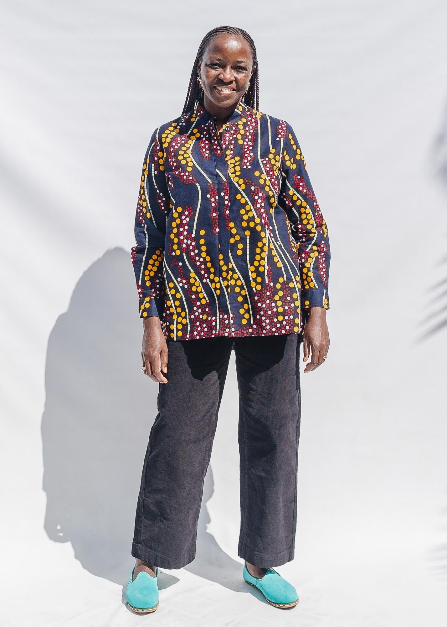 The model is wearing navy, yellow, white, red print shirt