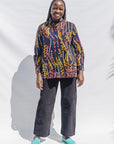 The model is wearing navy, yellow, white, red print shirt